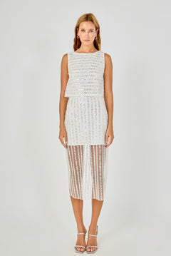Full-length front view of an off-white sleeveless sequin crop top featuring horizontal sequin stripes and a cropped hem, styled with a matching vertical sequin stripe sheer mesh midi skirt.