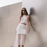 Full-length view of an off-white sleeveless crop top featuring horizontal sequin stripes, styled with a matching sequin skirt.