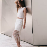 Full-length side profile view of an off-white high-waisted midi skirt featuring vertical sequin stripes, an opaque mini lining, a sheer lower hem, and a side slit.