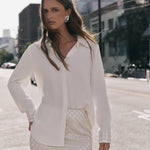 Front view of an ivory sequined mini skirt displaying the high-waisted fit and all-over diamond sequin pattern.