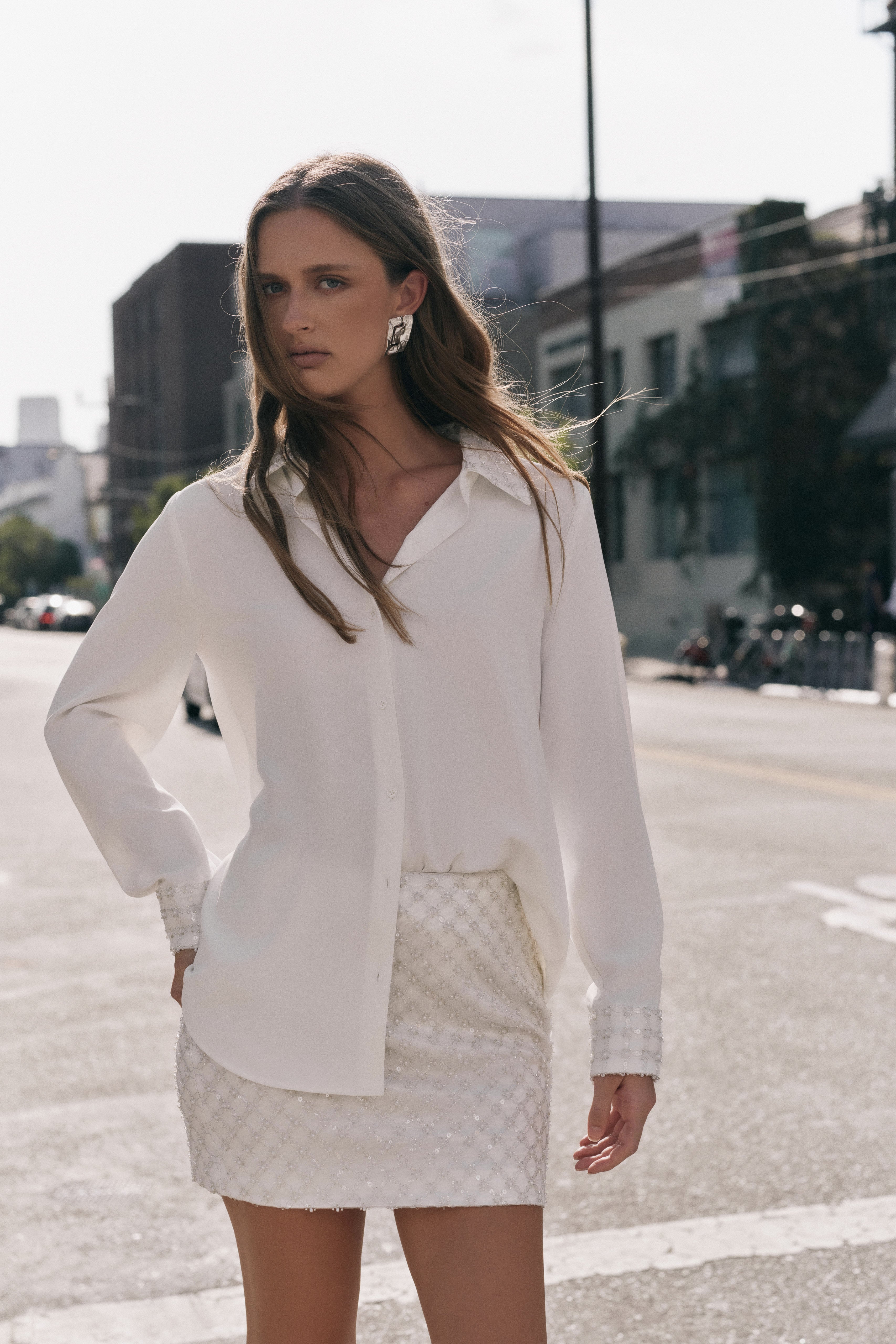 Front view of an ivory sequined mini skirt displaying the high-waisted fit and all-over diamond sequin pattern.