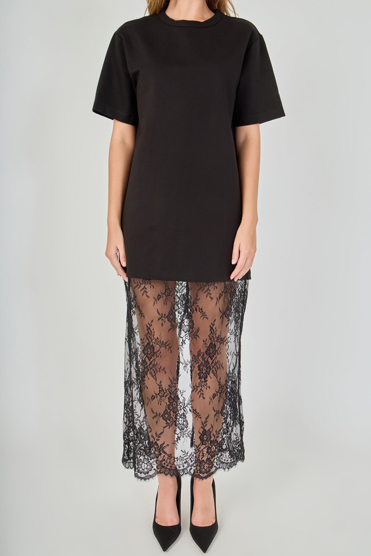 Close-up view of black mix media maxi dress featuring a crewneck short-sleeve t-shirt bodice and sheer floral lace trim.
