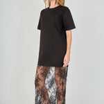Side view of black mix media maxi dress featuring a short-sleeve boxy t-shirt top and a sheer floral lace skirt.