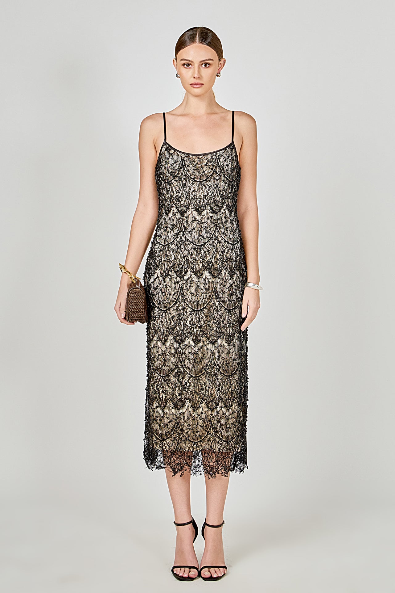 Black beaded lace midi dress featuring thin spaghetti straps, a scoop neckline, nude inner lining, and a scalloped hem with a side slit.