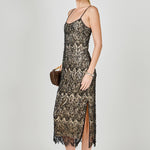 Side view of black beaded lace midi dress featuring thin spaghetti straps, a fitted silhouette, and a side slit.