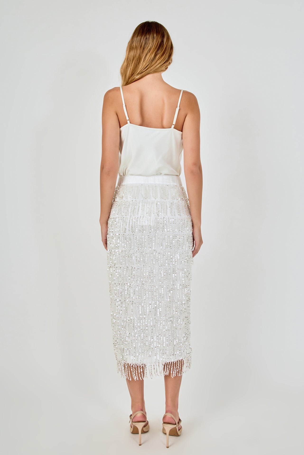 Back view of white high-waisted sequin fringe midi skirt showing the smooth rear waistband and full-length tiered sequin detailing.