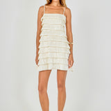 Full-length front view of a cream sleeveless mini dress featuring multi-layered pleated bubble tiers and thin shoulder straps.