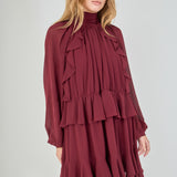 Model in a dynamic, slightly turned e-commerce pose with hands lightly at her sides, emphasizing the movement and voluminous drape of the tiered chiffon ruffled skirt.