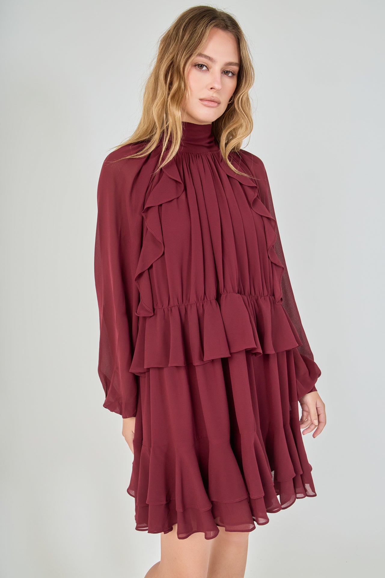 Model in a dynamic, slightly turned e-commerce pose with hands lightly at her sides, emphasizing the movement and voluminous drape of the tiered chiffon ruffled skirt.
