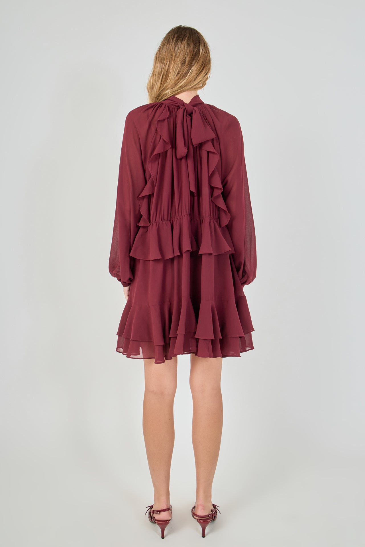 Back view of the deep burgundy chiffon mini dress, showing a clean back bodice with the multi-layered tiered cascading ruffles forming the entire lower skirt.