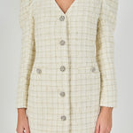 Upper bodice close-up view of an ivory windowpane tweed mini dress highlighting the V-neckline, puffed sleeve caps, and decorative crystal buttons.