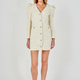 Full-length front view of an ivory long-sleeve tweed mini dress with structured puff shoulders, a central crystal button placket, and front flap accents.