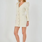 Side profile view of an ivory long-sleeve tweed mini dress showcasing the dramatic puffed shoulders and fitted mini silhouette.