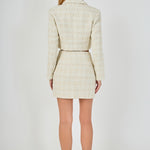 Straight-on back view of an ivory cropped tweed jacket and matching high-waisted mini skirt showing clean back seams and straight hem lines.