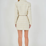 Straight-on back view of an ivory cropped tweed jacket and matching high-waisted mini skirt showing clean back seams and straight hem lines.