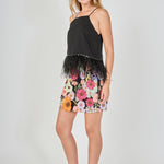 Side view of black floral embroidered mini skirt featuring a fitted mini cut and high-waisted fit.