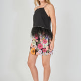 Side view of black floral embroidered mini skirt featuring a fitted mini cut and high-waisted fit.