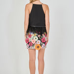 Back view of black floral embroidered mini skirt featuring all-over multi-colored flower embroidery and a straight mini hem.