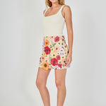 Side view of beige floral embroidered mini skirt featuring a fitted silhouette, high-waisted cut, and mini length.