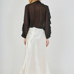 Back view of black sheer ruffled blouse showing the sheer chiffon back bodice and long sleeves.