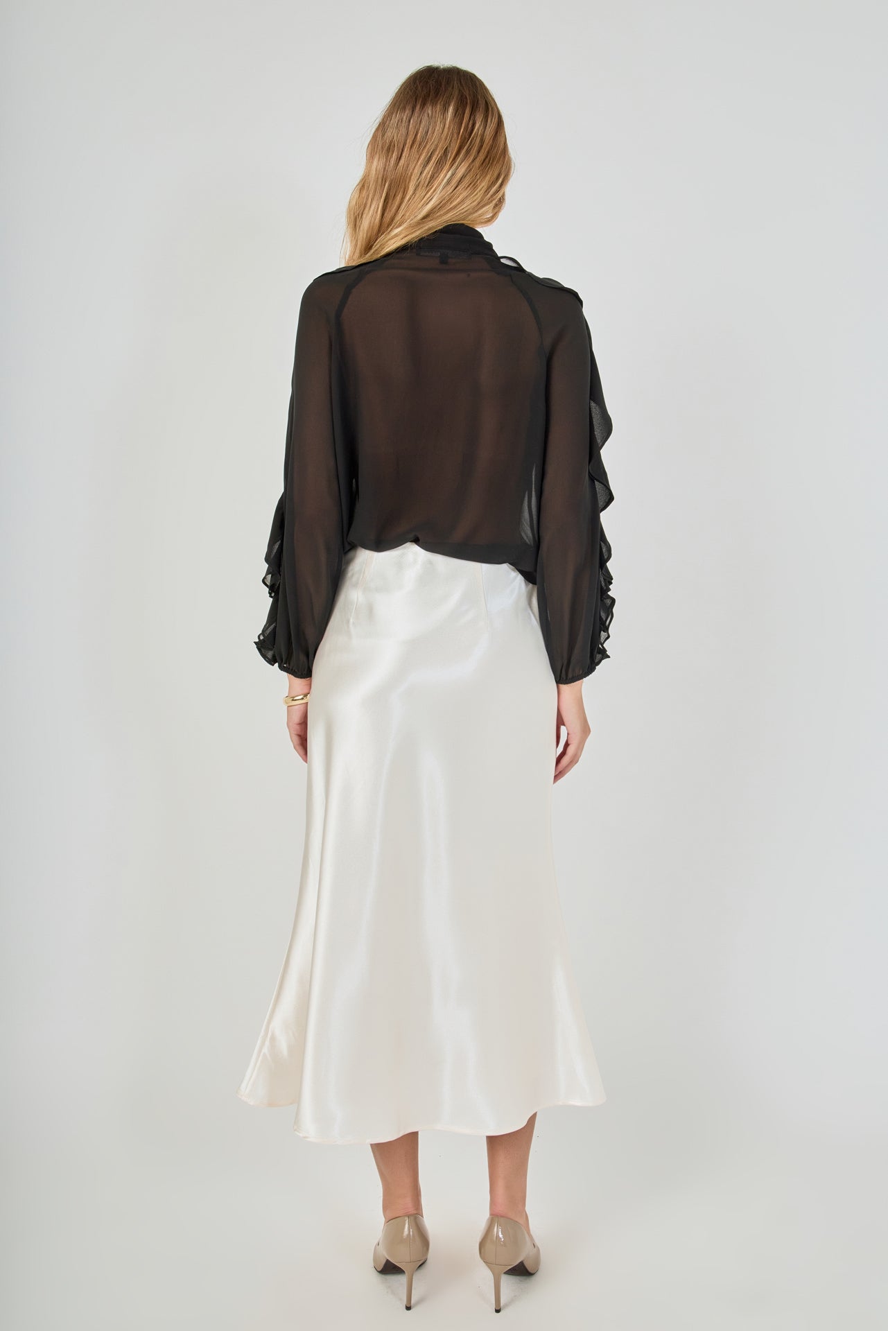 Back view of black sheer ruffled blouse showing the sheer chiffon back bodice and long sleeves.