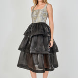 Side view of a mixed-media midi dress featuring a fitted floral jacquard bodice and a voluminous black tiered organza skirt.
