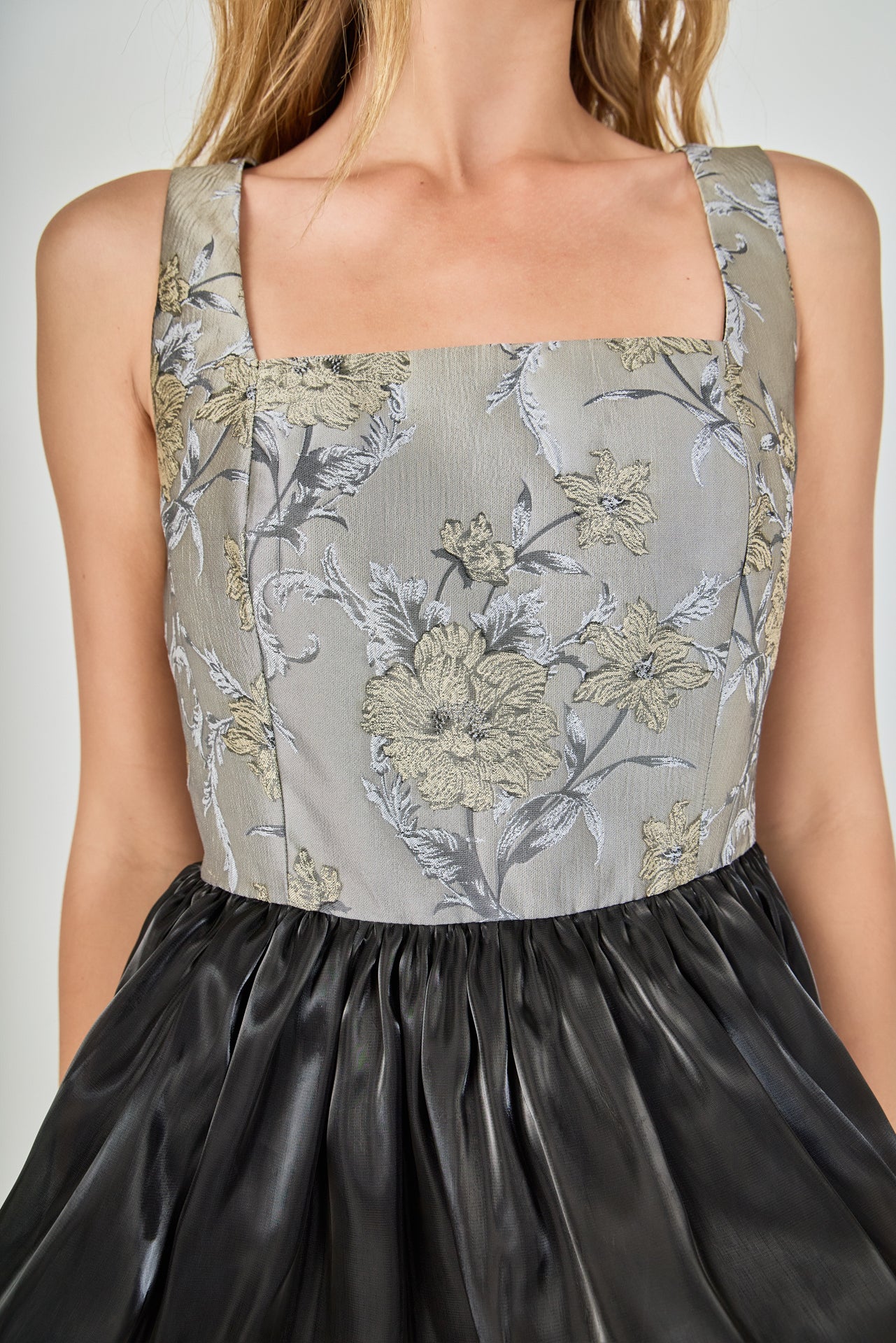 Detail view of grey and gold metallic floral jacquard fabric on the dress bodice, highlighting the intricate woven floral pattern and woven texture.
