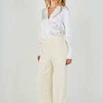 Side profile view of cream high-waisted wide-leg tweed trousers showcasing the relaxed leg fit and floor-length hem.