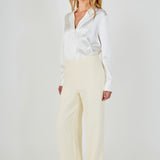 Side profile view of cream high-waisted wide-leg tweed trousers showcasing the relaxed leg fit and floor-length hem.