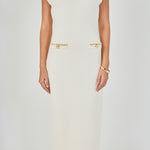 Close-up view of cream sleeveless knit maxi dress highlighting the ribbed crew neckline, cap shoulders, and four faux welt pockets detailed with metallic gold chain and button trim.