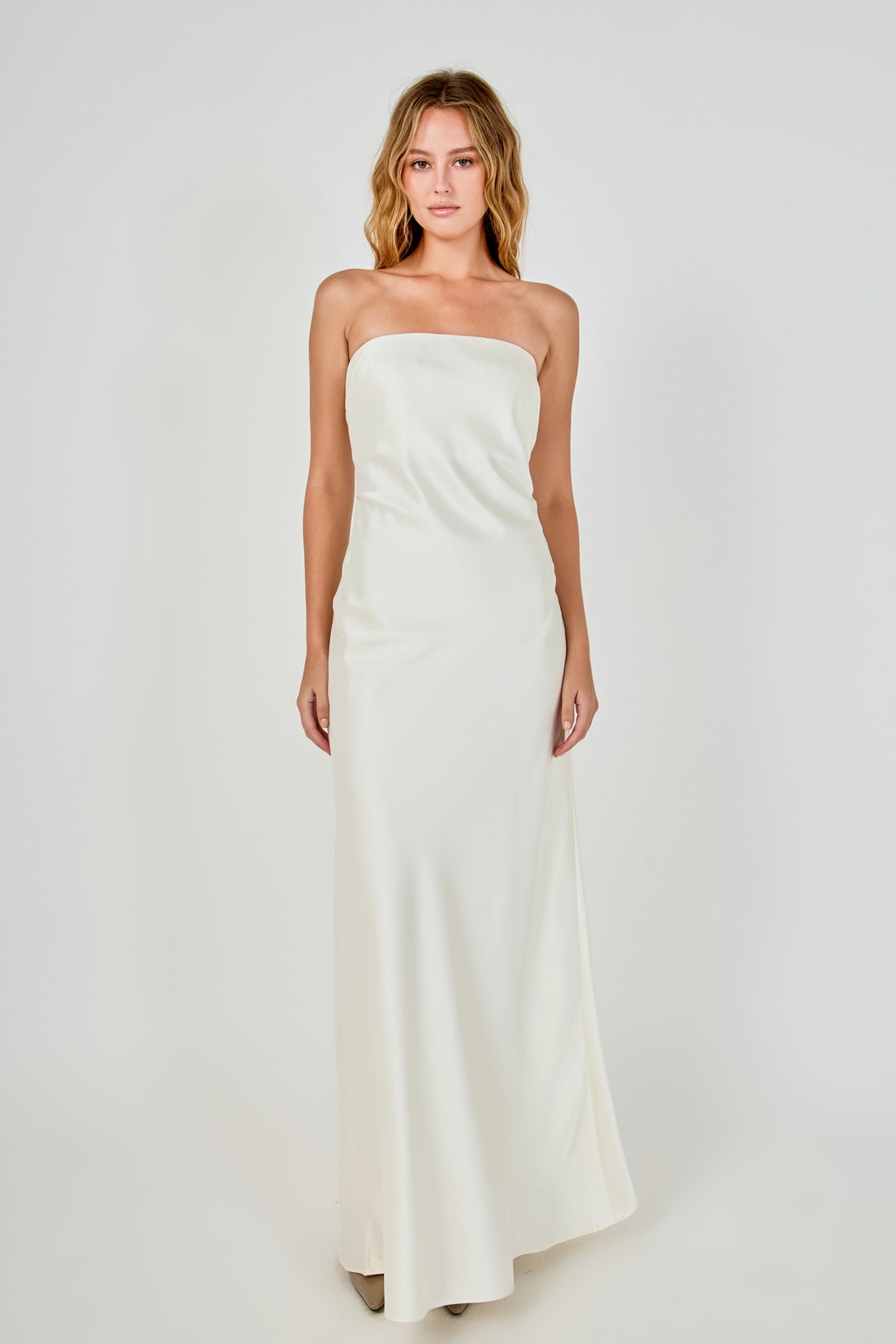 Full-length front view of an ivory strapless satin maxi dress showing the complete column fall to a floor-length hem.