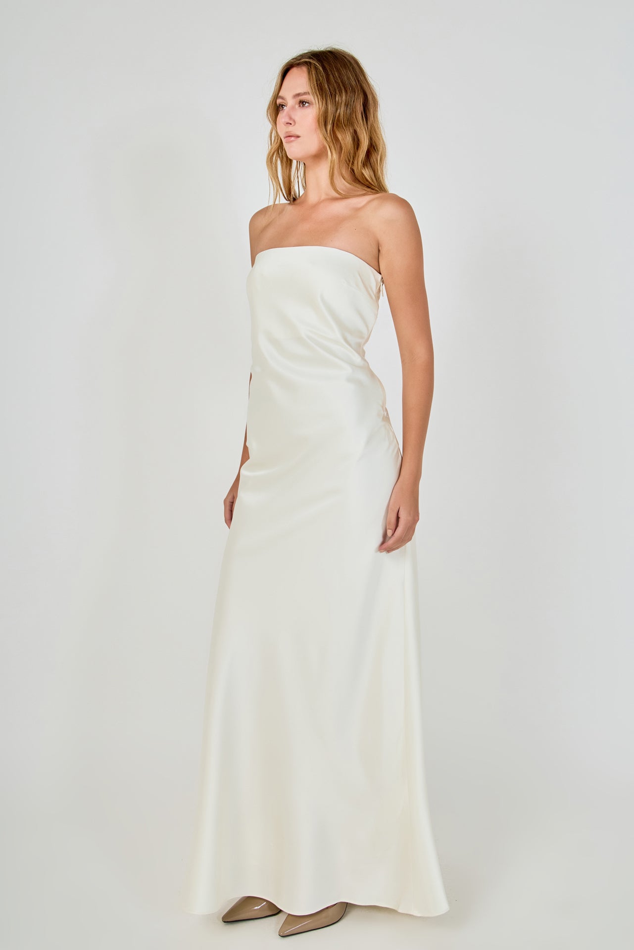 Side profile view of an ivory strapless satin maxi dress showing the sleek body-skimming fit and clean lateral seam.