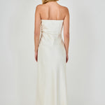 Straight-on rear view of an ivory strapless satin maxi dress displaying the straight back neckline, structured back seams, and fluid skirt fall.