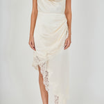 Upper body close-up view of a champagne satin halter dress featuring a draped cowl neckline and draped asymmetrical lace-trimmed skirt.
