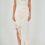 Upper body close-up view of a champagne satin halter dress featuring a draped cowl neckline and draped asymmetrical lace-trimmed skirt.