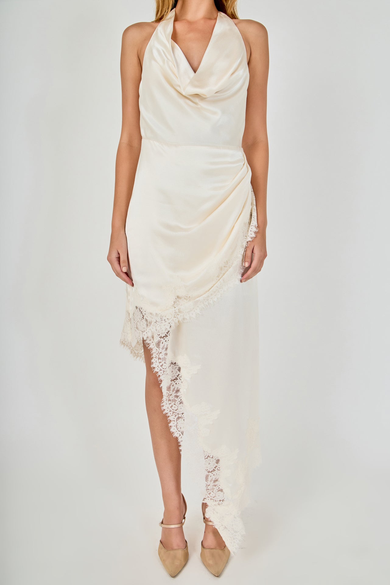 Upper body close-up view of a champagne satin halter dress featuring a draped cowl neckline and draped asymmetrical lace-trimmed skirt.