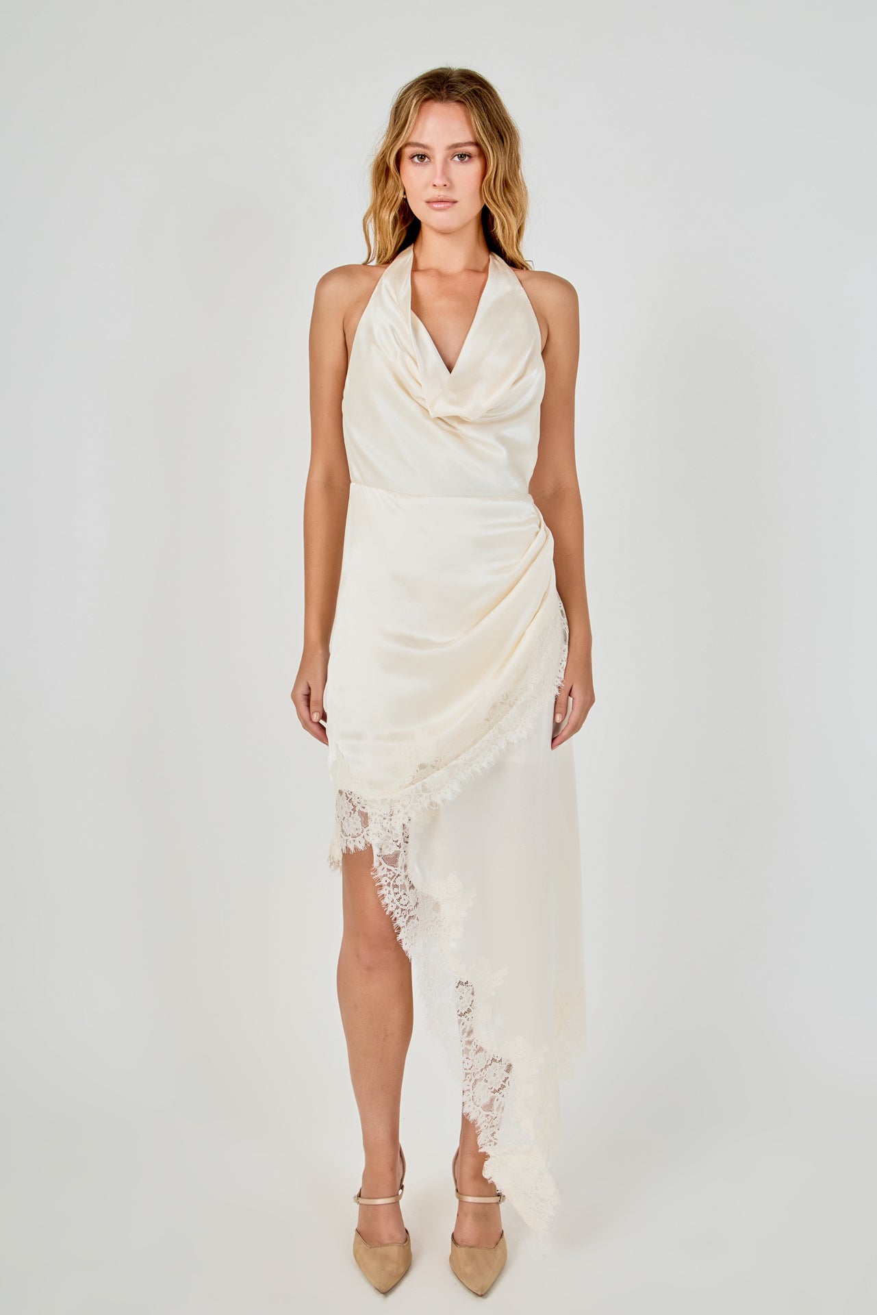 Full-length front view of a champagne satin halter dress with a draped cowl neckline, asymmetrical skirt drape, and eyelash lace trim.