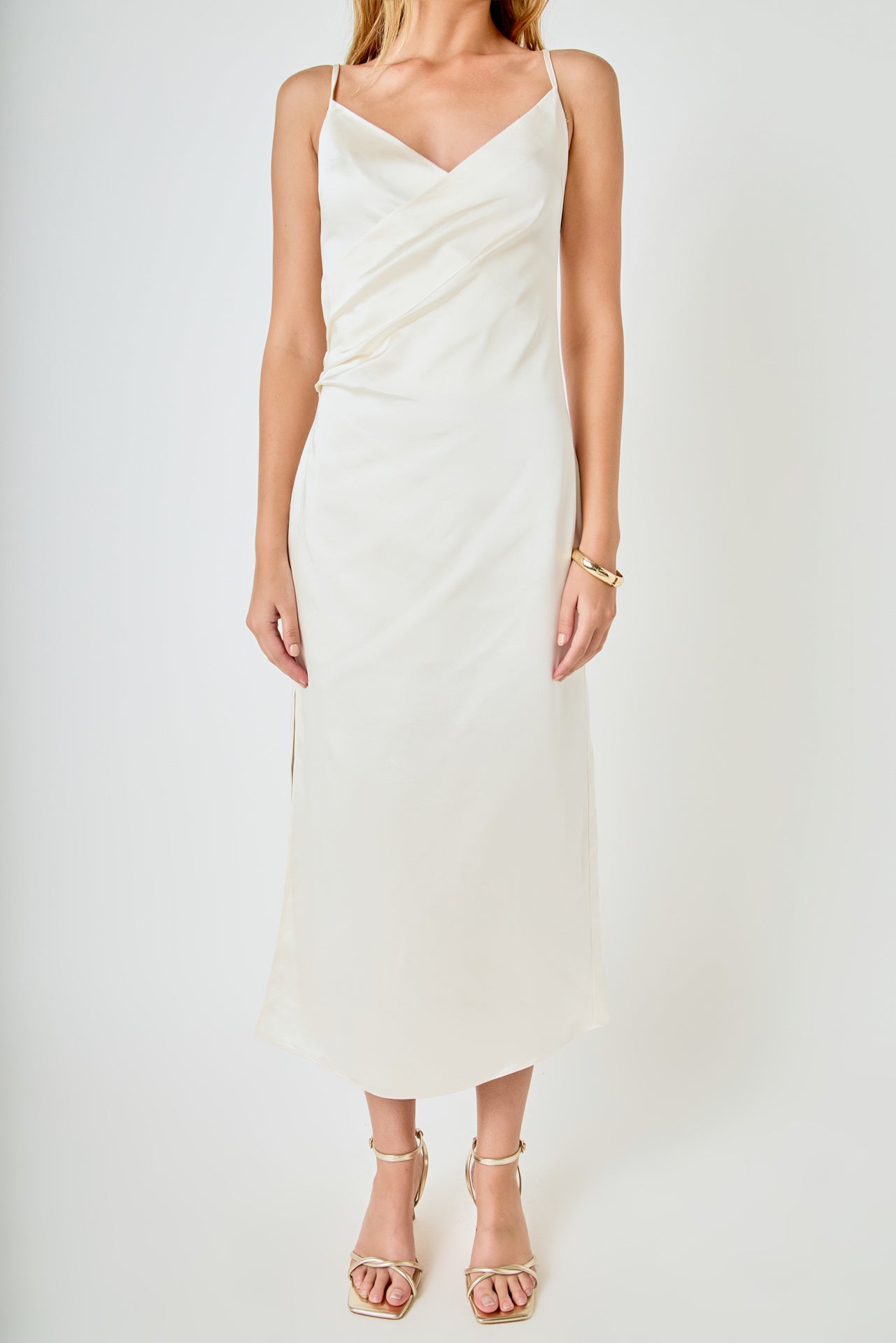 Upper bodice close-up view of a champagne satin wrap midi dress highlighting the draped wrap bust and side ruched seam.