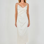 Full-length front view of a champagne satin wrap midi dress showcasing the wrap neckline, ruched waist detail, and straight skirt silhouette.