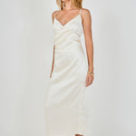 Side profile view of a champagne satin wrap midi dress displaying the slim-fitting drape and discreet side zipper detail.