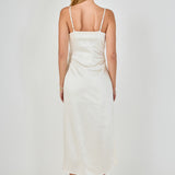 Straight-on rear view of a champagne satin wrap midi dress showing the slender adjustable shoulder straps and smooth back drape.