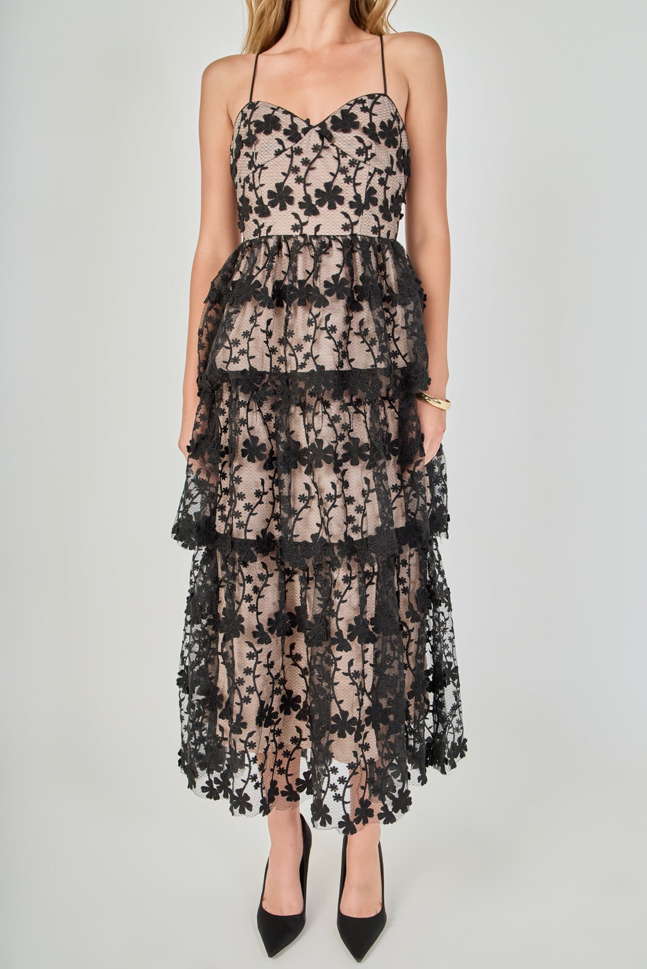 Close-up view of the dress bodice highlighting the sweetheart neckline, bustier seams, fitted waist, and intricate black floral embroidery over contrast beige lining.