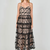Full-length front view of a black floral embroidered tiered midi dress featuring a sweetheart neckline, thin spaghetti straps, sheer mesh overlay with black floral embroidery, contrast beige lining, and a tiered ruffled skirt.