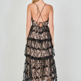 Back view of a black floral embroidered tiered midi dress featuring thin spaghetti straps, a straight back neckline, and a multi-tiered ruffled midi hem.