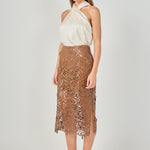 Side profile view of an ivory satin crossover halter top showing the sleeveless drape and fluid silhouette.
