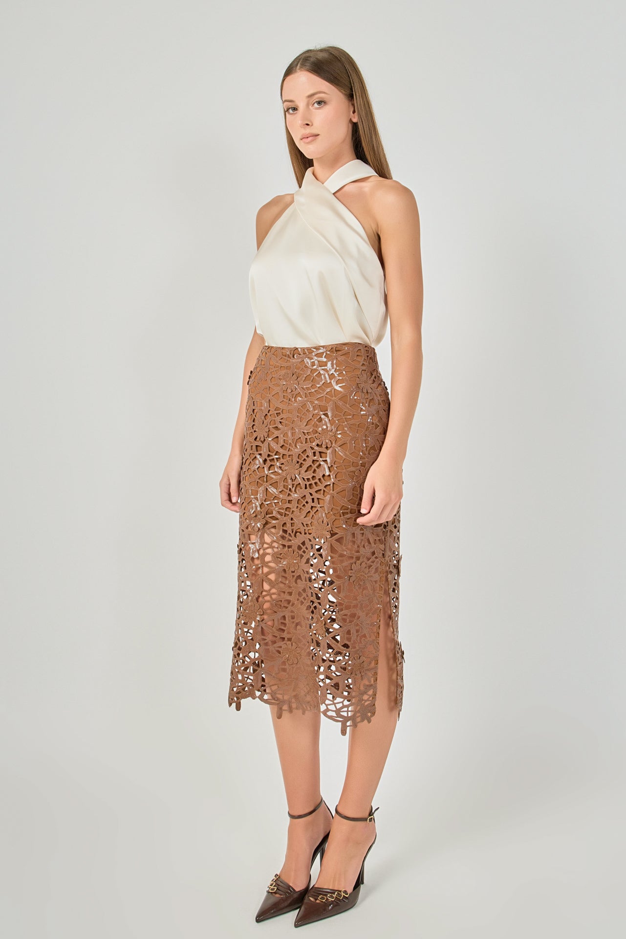 Side profile view of an ivory satin crossover halter top showing the sleeveless drape and fluid silhouette.