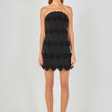Black strapless mini dress featuring horizontal floral appliqué trim, scalloped neckline and hem, and a fitted silhouette.