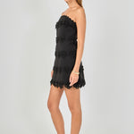 Side view of black strapless mini dress featuring horizontal floral appliqué trim, side zipper closure, and a fitted mini cut.