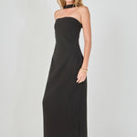 Side view of a black strapless column maxi dress featuring a slim fitted silhouette and matching neckband detail.