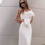 Posed three-quarter view of an ivory satin slip maxi skirt displaying the flat front waist and soft satin finish.